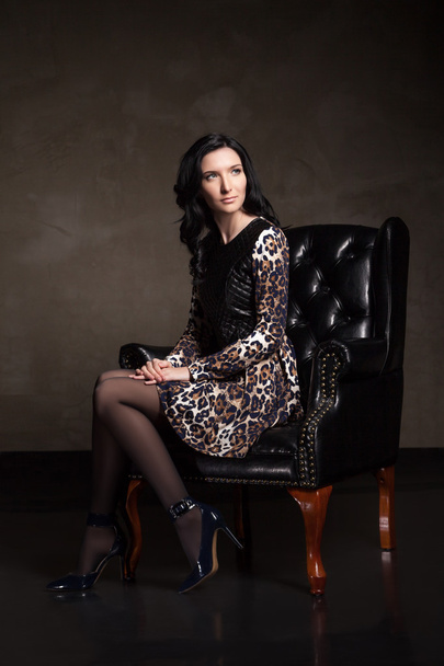 beautiful woman in big black leather armchair - Foto, Bild