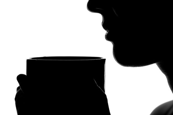 silhouette of a woman with a cup in hands - Фото, зображення