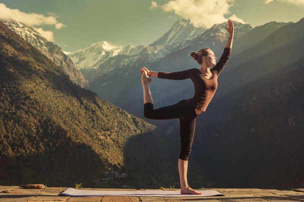 Young woman doing yoga in mountains - Фото, изображение