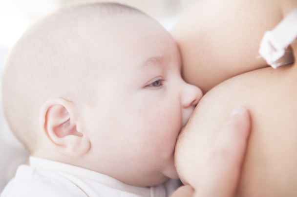 Дитина під час годування грудьми
 - Фото, зображення