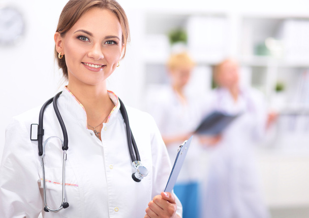 Woman doctor standing with folder at hospital - Фото, зображення