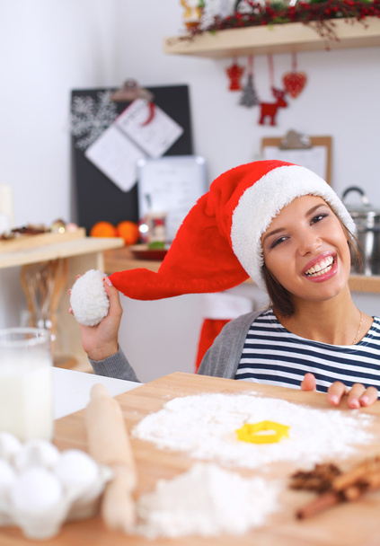 Mutlu genç bayan gülümsüyor Noel hazırlıklarıyla eğleniyor Noel Baba şapkası takıyor. - Fotoğraf, Görsel