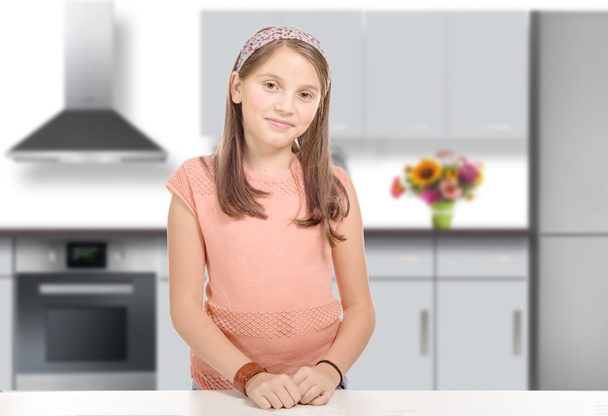  smiling young girl in a kitchen - Φωτογραφία, εικόνα