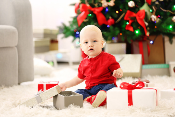 baby with gift boxes and Christmas tree - Foto, Bild