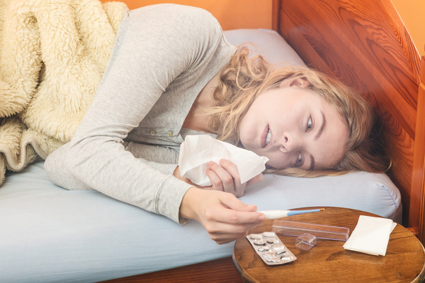 woman in bed sneezing in tissue. - Foto, imagen