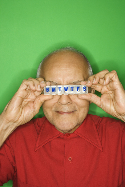Man holding pill organizer. - Foto, afbeelding