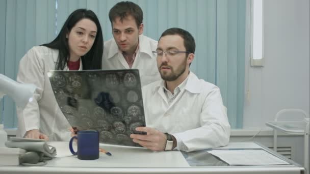 трио молодых испуганных врачей, проверяющих пациентов на сканирование головы
 - Кадры, видео