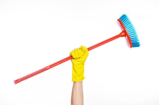 Cleaning the house topic: human hand in yellow rubber gloves holding a red broom isolated on a white background in studio - Foto, immagini