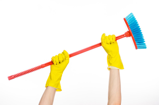 Cleaning the house topic: human hand in yellow rubber gloves holding a red broom isolated on a white background in studio - Fotografie, Obrázek