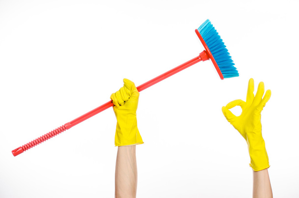 Cleaning the house topic: human hand in yellow rubber gloves holding a red broom isolated on a white background in studio - Photo, Image