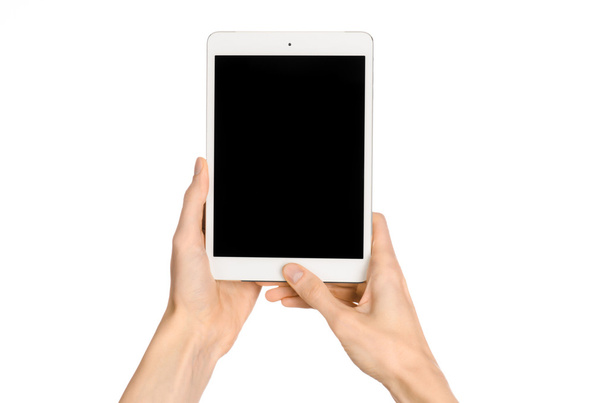 Presentation and advertising touchscreen topic: human hand holding a white tablet touch computer gadget with touch blank black screen isolated on a white background in the studio, first-person view - Fotó, kép