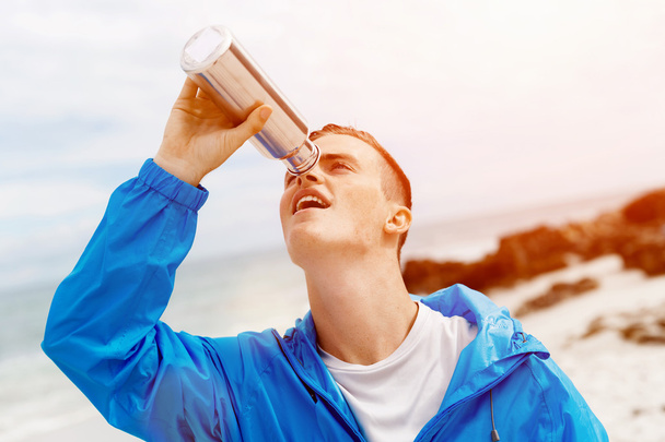 Hombre bebiendo de una botella deportiva
 - Foto, Imagen