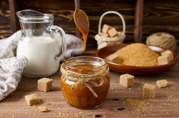 Homemade caramel sauce on wooden table - Zdjęcie, obraz