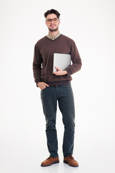 Smiling man holding laptop computer and looking at camera - Foto, afbeelding