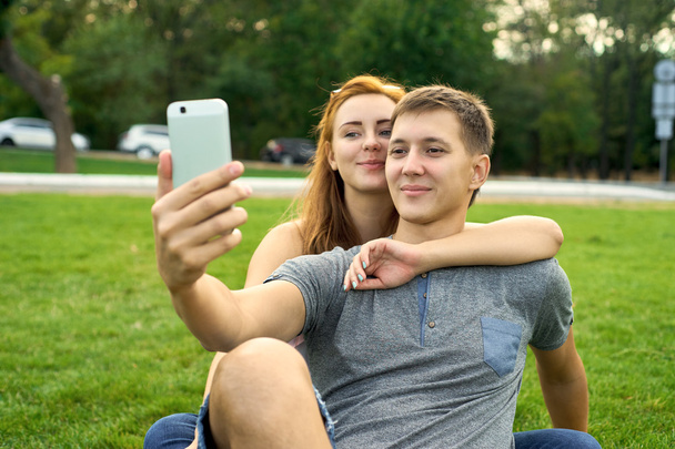 芝生の上の愛のカップルは、自己 - 写真・画像