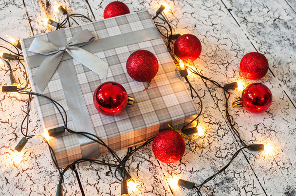Fondo de Navidad, luces de guirnalda, regalo, bolas rojas en madera
 - Foto, Imagen