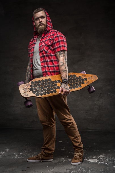 A man in red shirt holding long board. - Photo, image