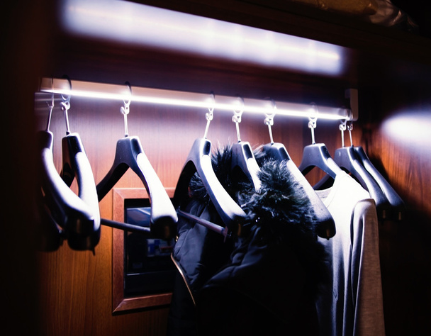 clothers kapstok in bruine kledingkast hangen - Foto, afbeelding