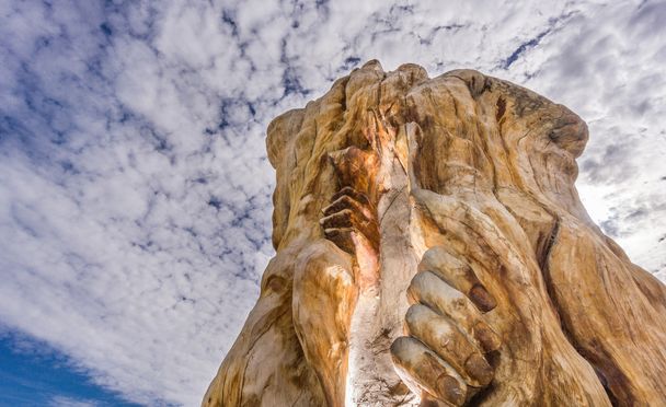 Mãos e tronco escultura em Tordesilhas contra céu nublado
 - Foto, Imagem