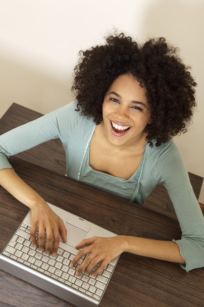 Curly young woman using laptop - Photo, Image