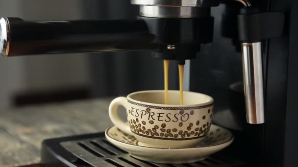 Μηχανή espresso που ρίχνει ισχυρή εξετάζει ένα τακτοποιημένο φλιτζάνι φρέσκο καφέ - Πλάνα, βίντεο