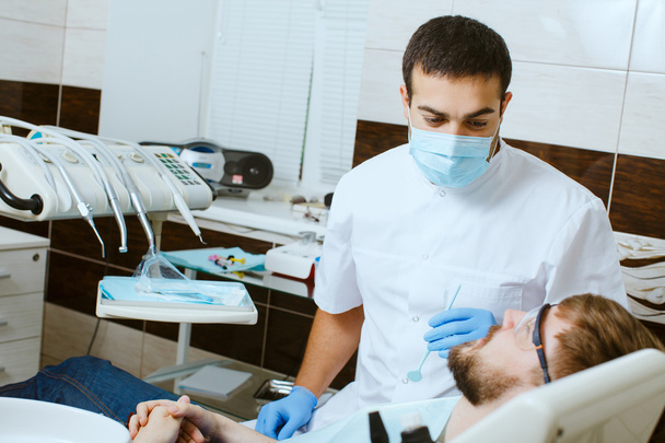 Dentiste en masque médical avec patient masculin
 - Photo, image