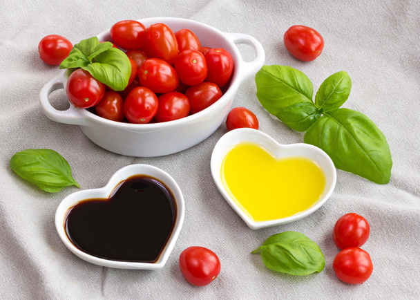 Aperitivo de tomates, albahaca, aceite y vinagre para hacer una ensalada saludable
 - Foto, imagen