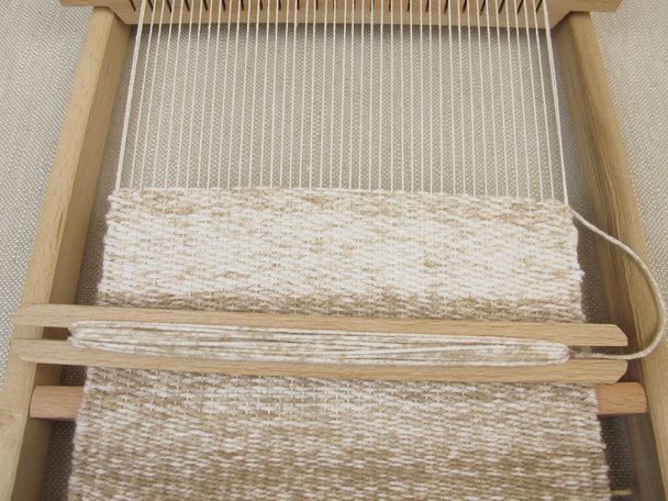 Met het frame en bruine wol te weven weven - Foto, afbeelding