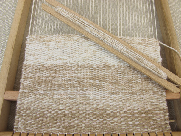 Tessitura con telaio di tessitura e lana marrone
 - Foto, immagini