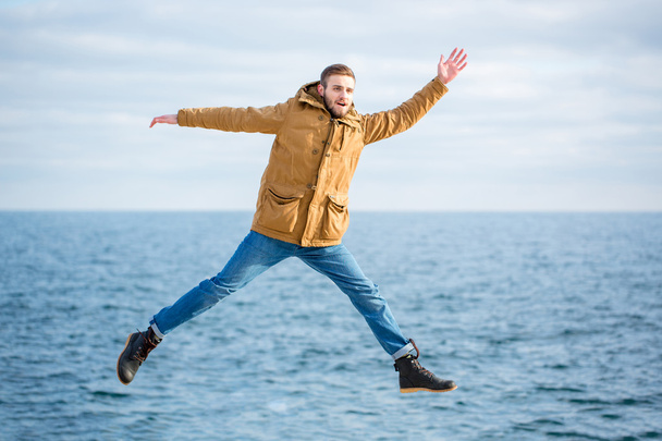 Hauska mies hyppää mereen tausta
 - Valokuva, kuva