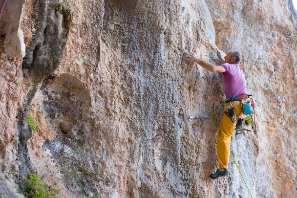 rock climber climbs on a rocky wall. - Foto, imagen
