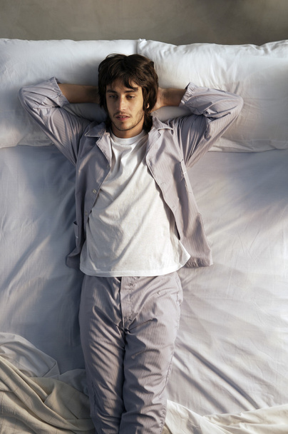 young man lying in bed - Zdjęcie, obraz