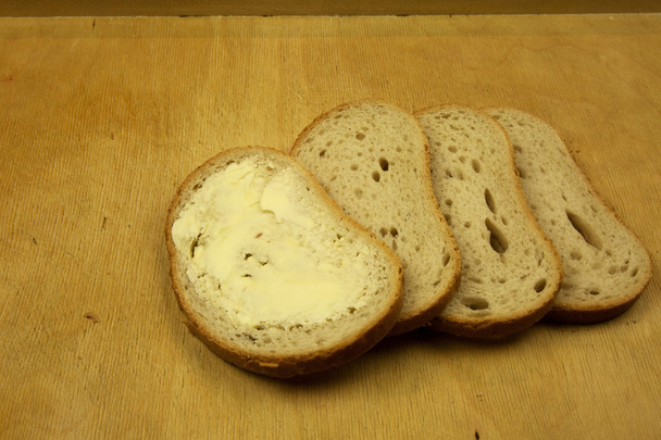 Quatre tranches de pain frais sur une vieille planche à pâtisserie
 - Photo, image