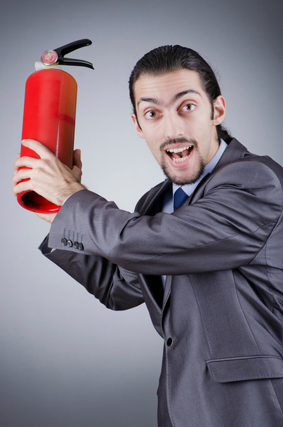 Man with fire extinguisher in firefighting concept - Foto, imagen