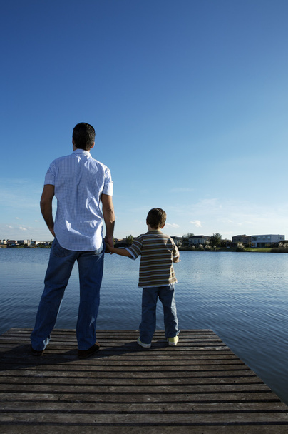 Ojciec i syn stojąc na drewnianym molo  - Zdjęcie, obraz
