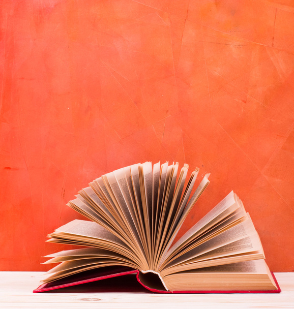 aufgeschlagenes Buch, Tagebuch mit aufgefächerten Seiten auf rotem Hintergrund. - Foto, Bild