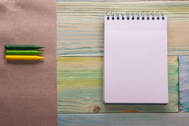 Vista superior del libro de notas en blanco, calendario con lápices de colores. De vuelta a la escuela, espacio para copiar. Educación fondo de madera. Arte, artista, arte
 - Foto, imagen