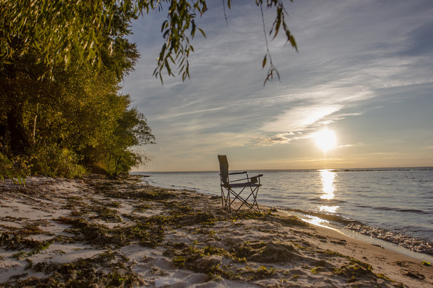 Sommer Reise Konzept Hintergrund Stuhl auf verschwommenem Meer Sonnenuntergang Hintergrund - Foto, Bild