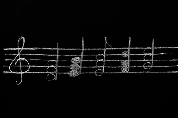 Ένα μαυροπίνακα με μουσικές νότες - Φωτογραφία, εικόνα