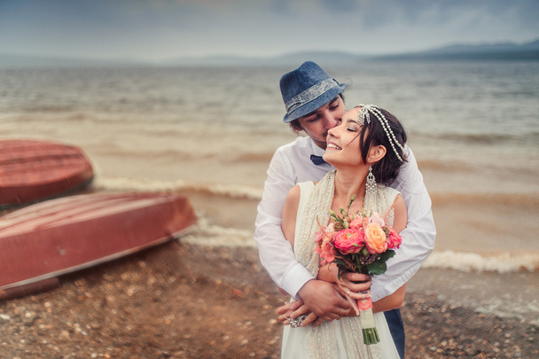 Свадьба Бохо. красивая пара целуется на побережье
 - Фото, изображение