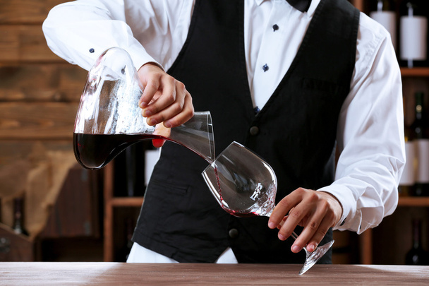Bartender working at counter on bar background - Foto, Imagen