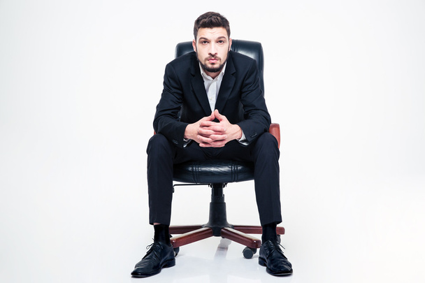Handsome young businessman with beard sitting in black office chair - Фото, зображення