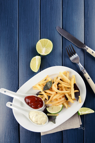 French fried potatoes with sauce and lime on white tray - Fotografie, Obrázek
