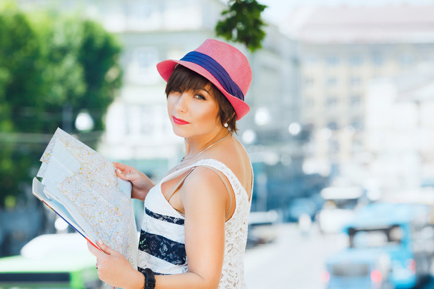 туристична дівчина тримає велику карту
 - Фото, зображення