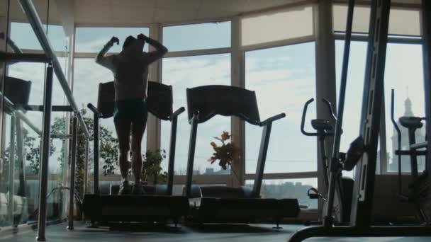Futás a futópad sport edzőteremben, vonzó nő - Felvétel, videó