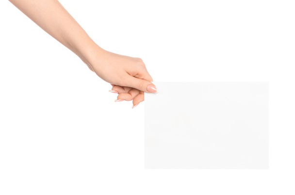 ブランディングと広告のテーマ: 白い背景に分離された空白のホワイト ペーパー カードを持っている美しい女性の手 - 写真・画像