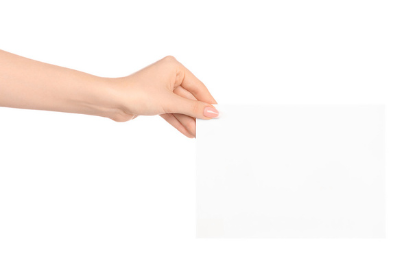 Branding and advertising theme: beautiful female hand holding a blank white paper card isolated on white background - Fotoğraf, Görsel