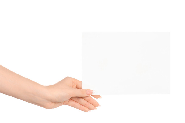 Branding and advertising theme: beautiful female hand holding a blank white paper card isolated on white background - 写真・画像