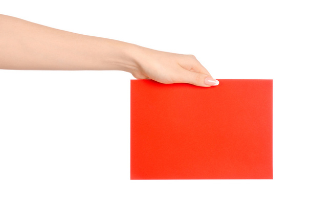 Branding and advertising theme: beautiful female hand holding a blank red paper card isolated on white background - Foto, imagen