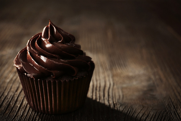 Chocolate cupcake on wooden table - Фото, зображення